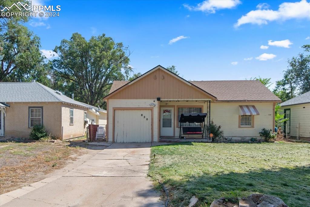 View of front facade featuring a garage and a front yard