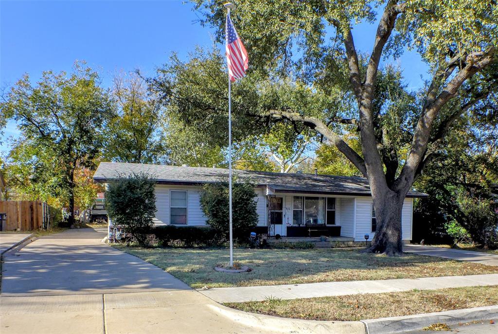 a view of a house with street that has a tree