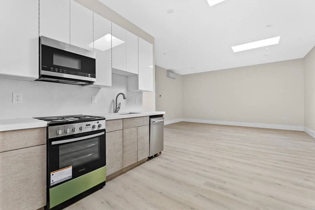 a kitchen with stainless steel appliances a stove a microwave and sink