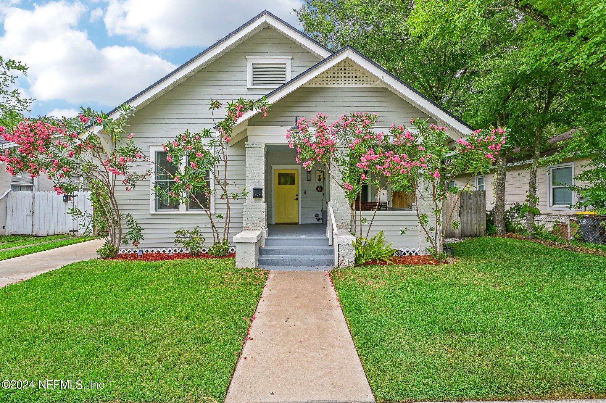 a front view of a house with a yard and fountain