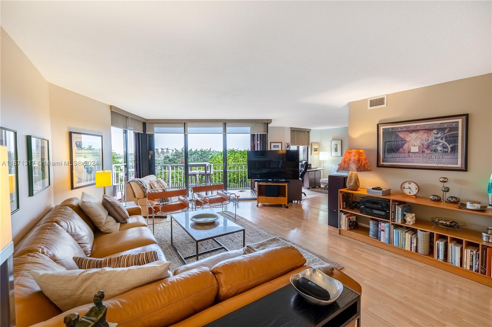 a living room with furniture a flat screen tv and a floor to ceiling window