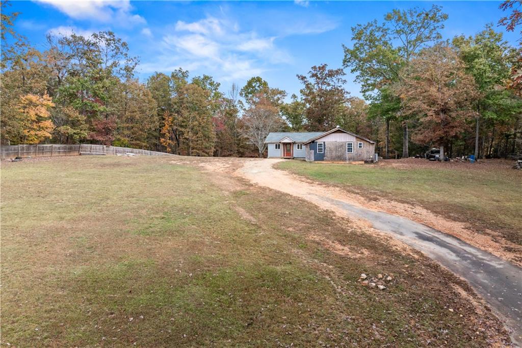 a front view of a house with a yard and trees