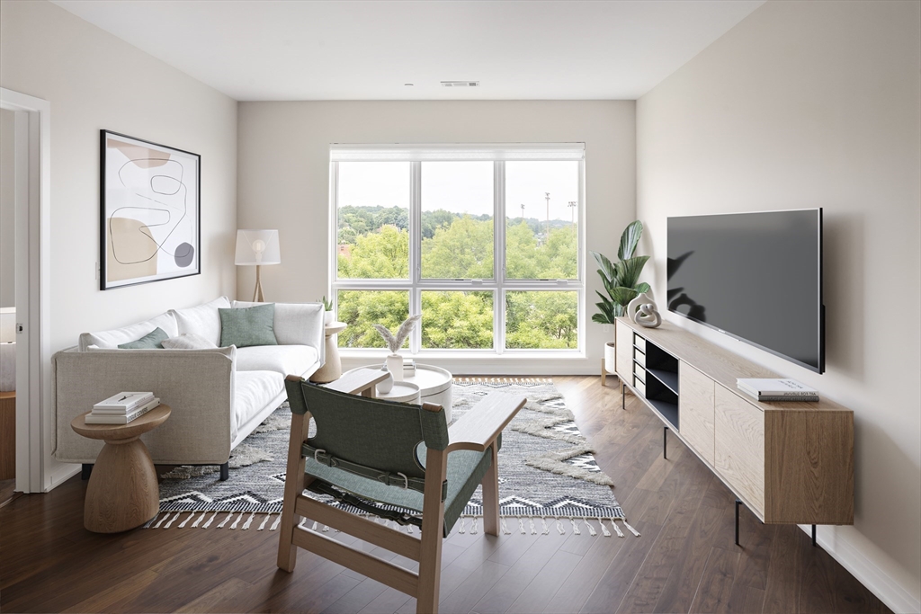 a living room with furniture a flat screen tv and a window