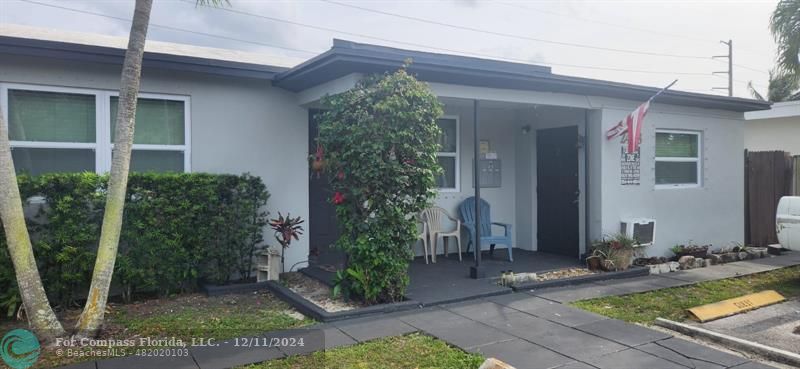 a view of a house with a small yard plants and large tree