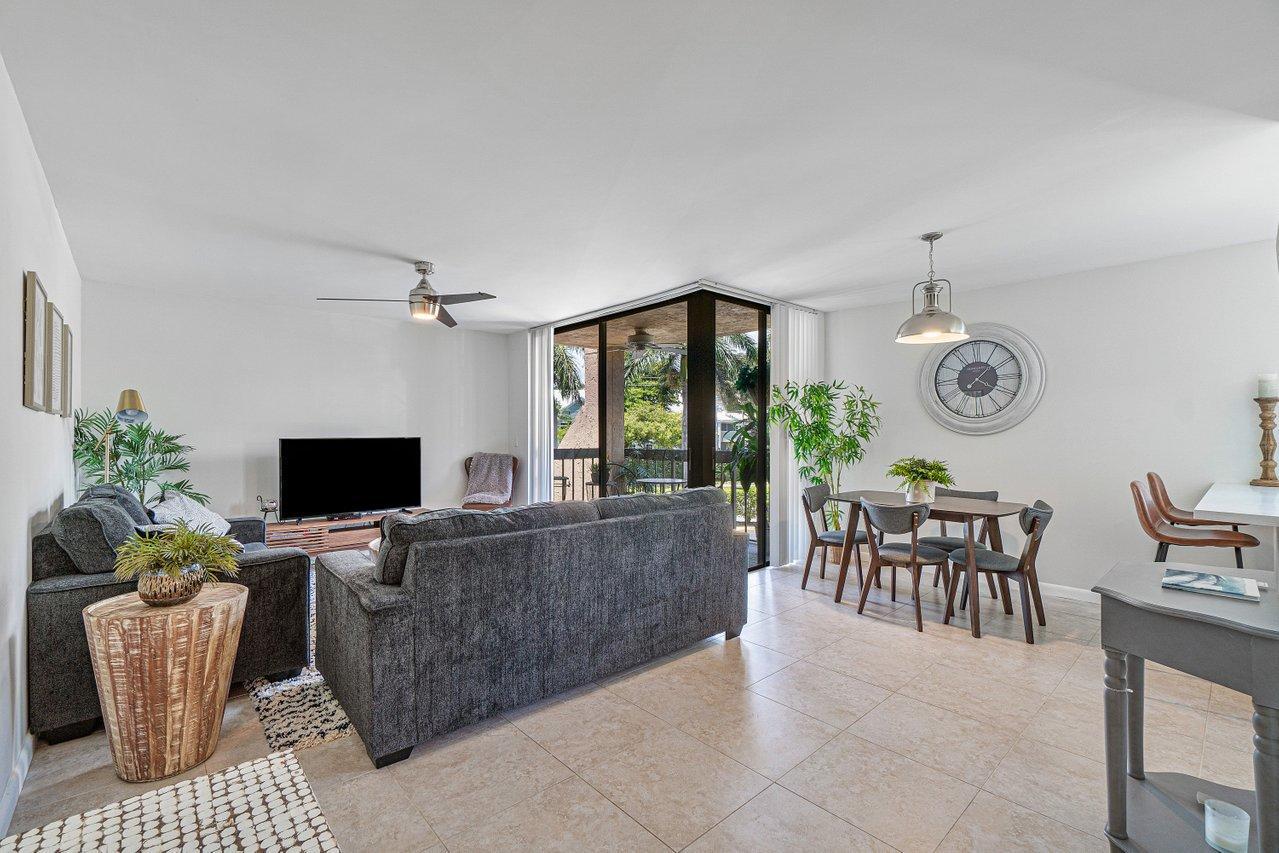 a living room with furniture a dining table and a flat screen tv