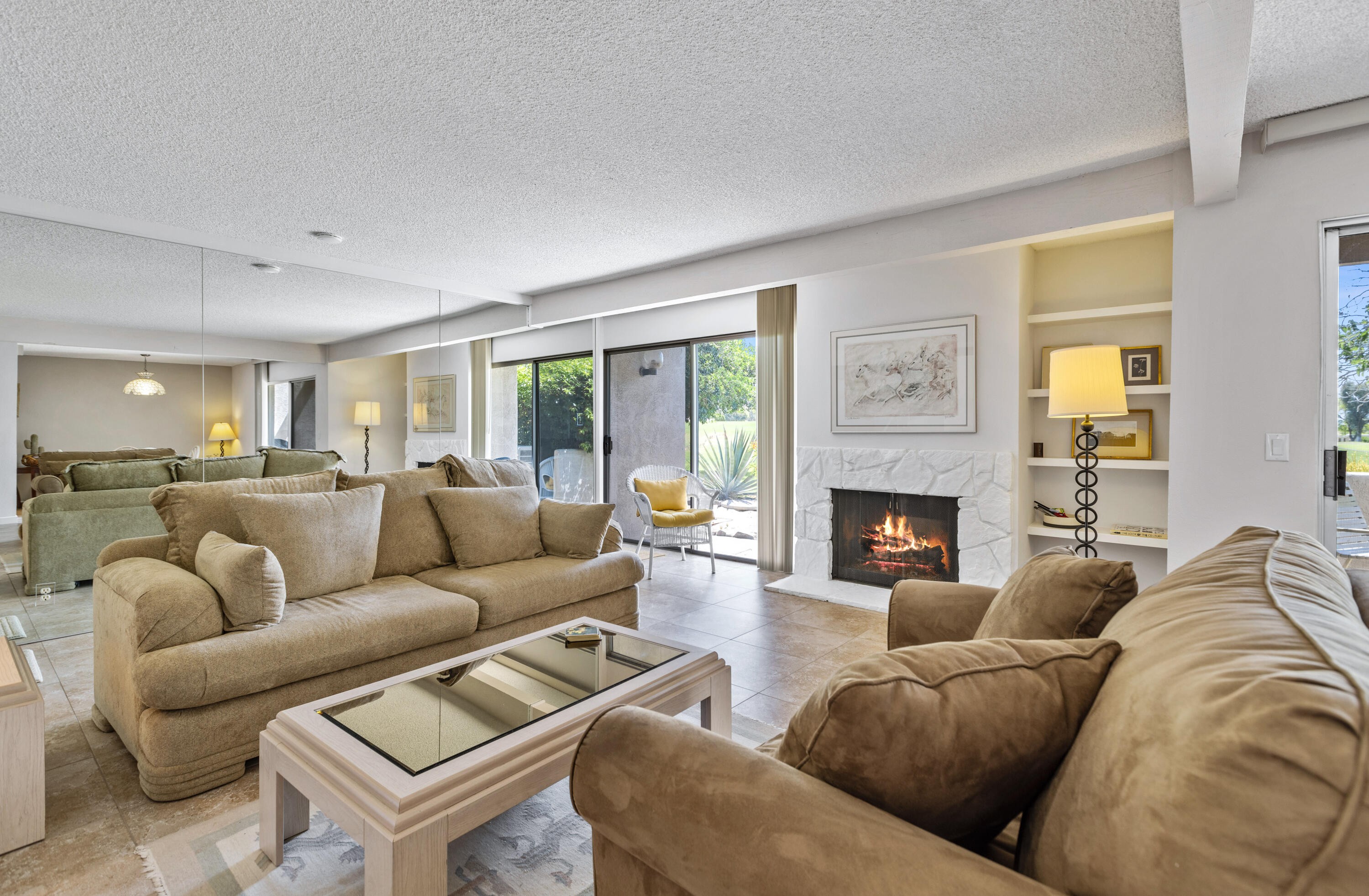 a living room with furniture a fireplace and a large window