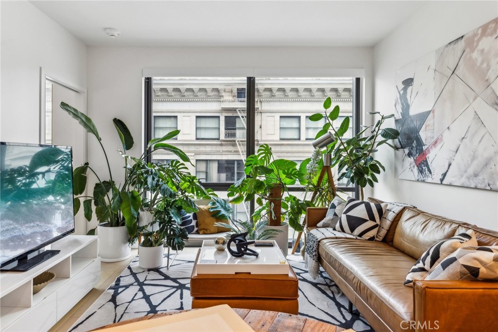 a living room with patio furniture and potted plants