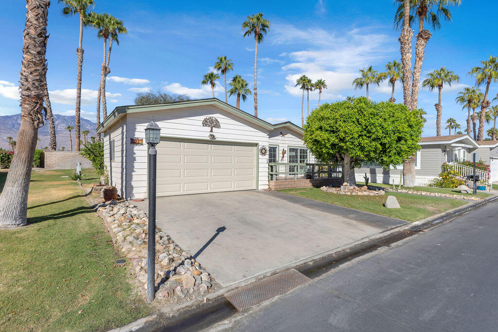 a view of a house with a yard and a street