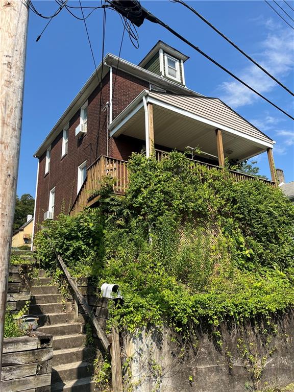 a front view of a house with plants