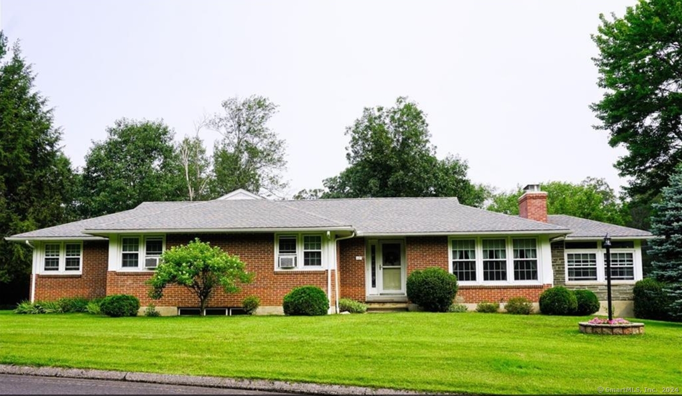 a front view of a house with a yard and potted plants