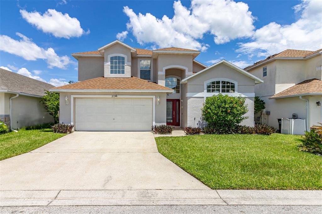 a front view of a house with a yard and garage