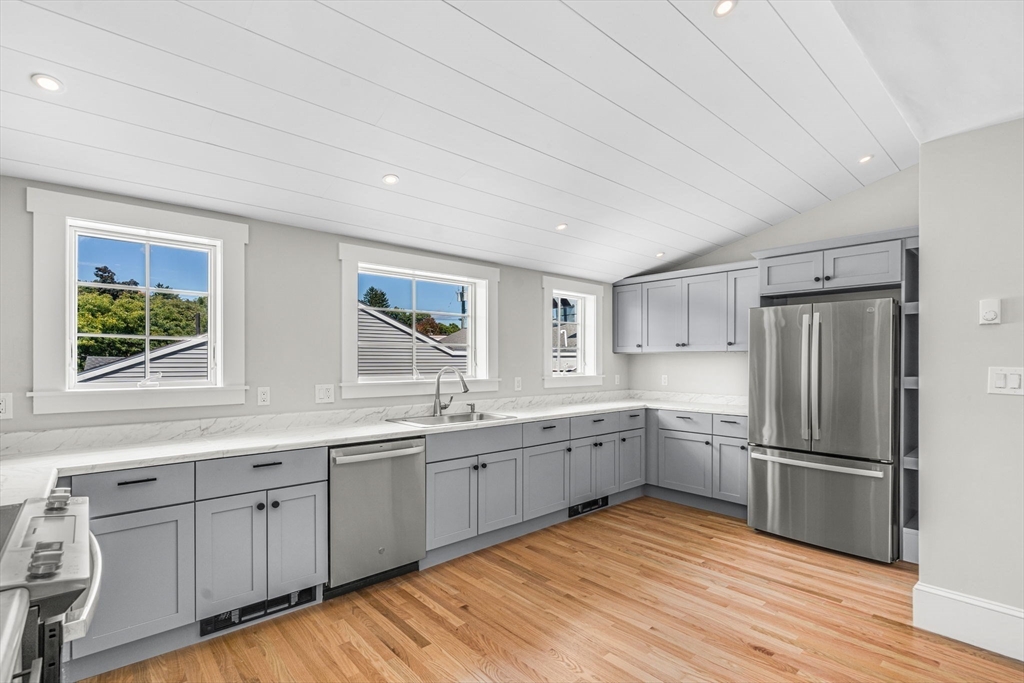 a kitchen with white cabinets sink and stainless steel appliances