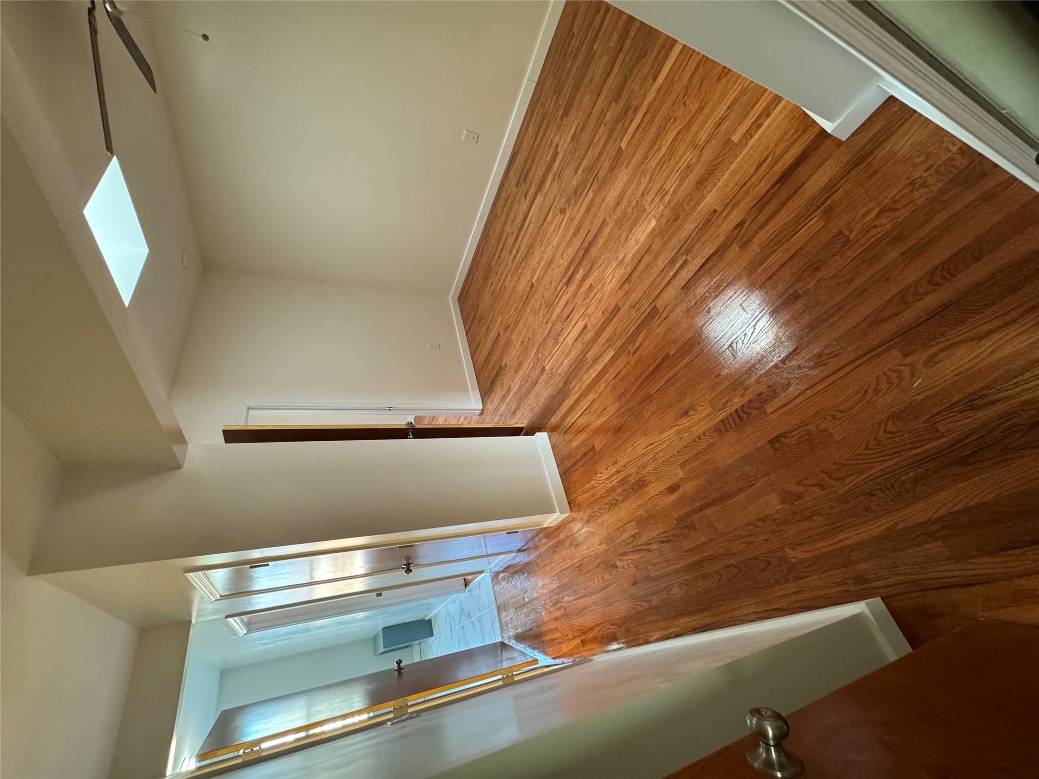 Unfurnished room with wood-type flooring, a skylight, and ceiling fan