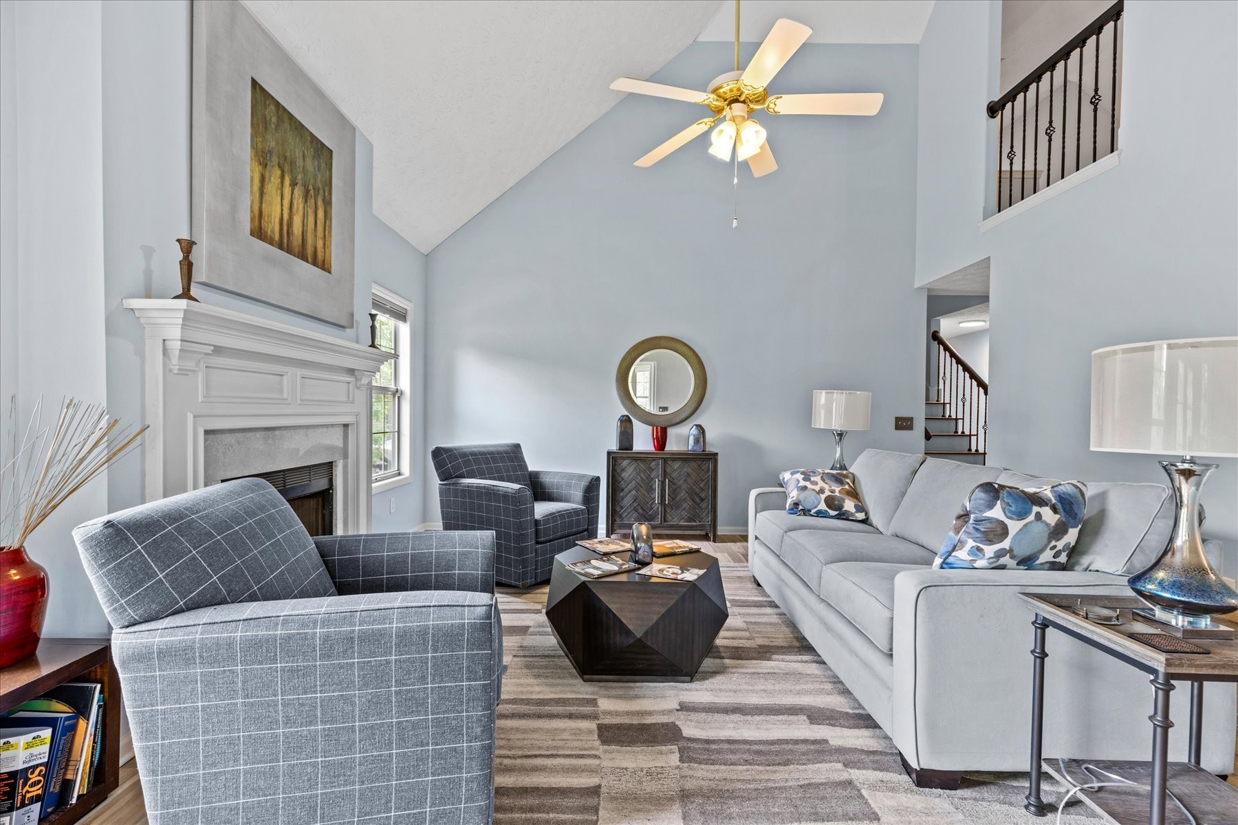 a living room with furniture a fireplace and a chandelier