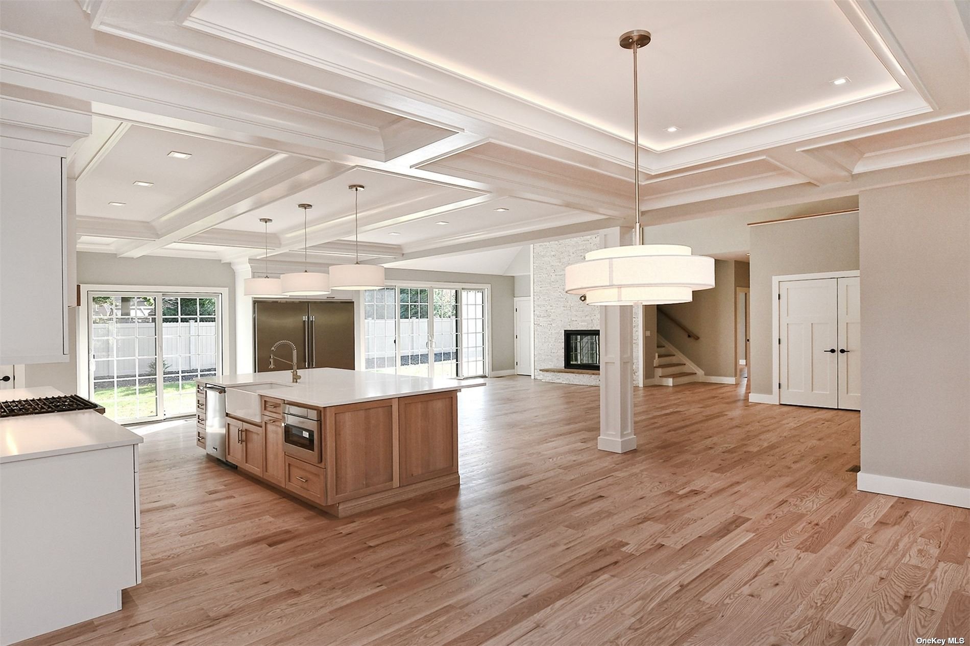 a living room with stainless steel appliances granite countertop furniture and a chandelier