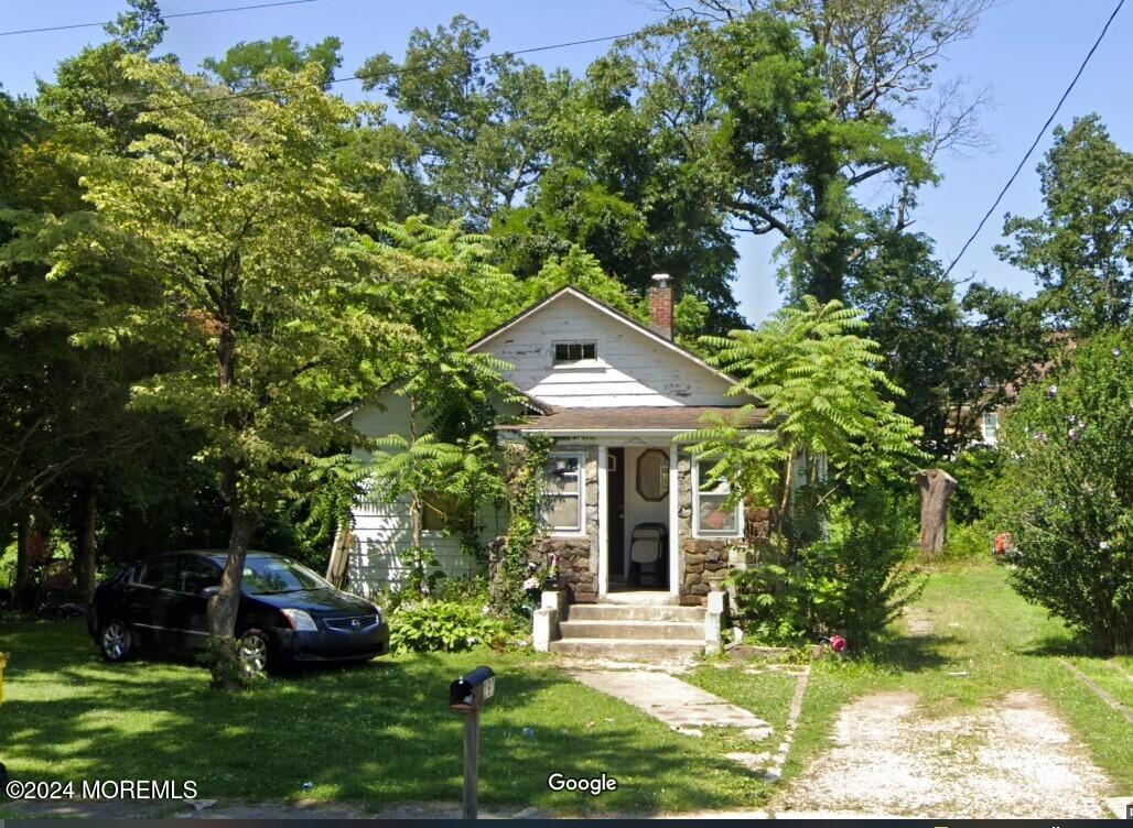 a front view of a house with a garden and trees