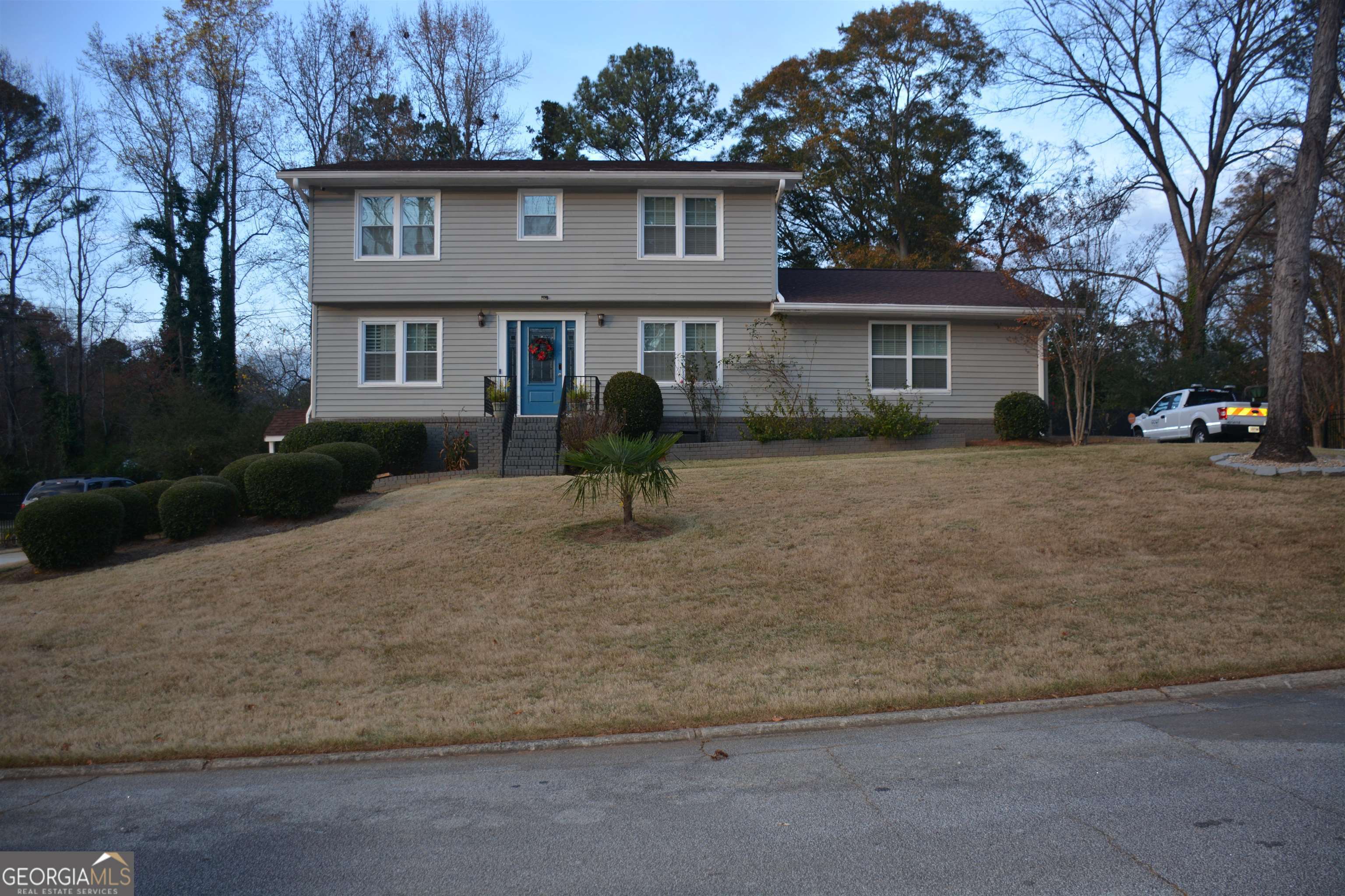 a front view of a house with a yard and trees