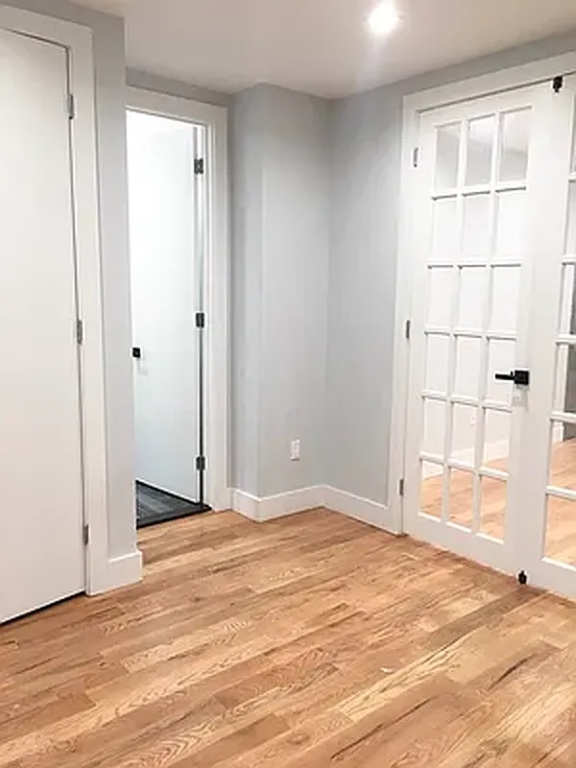 a view of an empty room with wooden floor and entryway