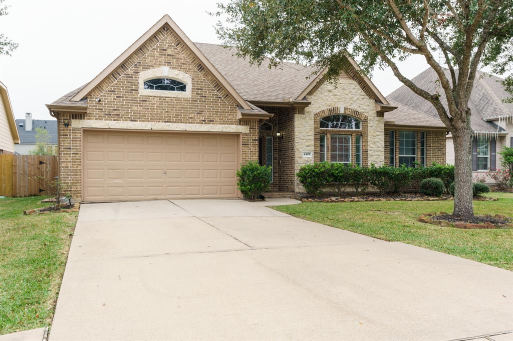 Charming single-story brick home with a two-car garage, manicured front lawn, and mature trees. Features a welcoming entryway and large windows for natural light. Ideal for comfortable family living.