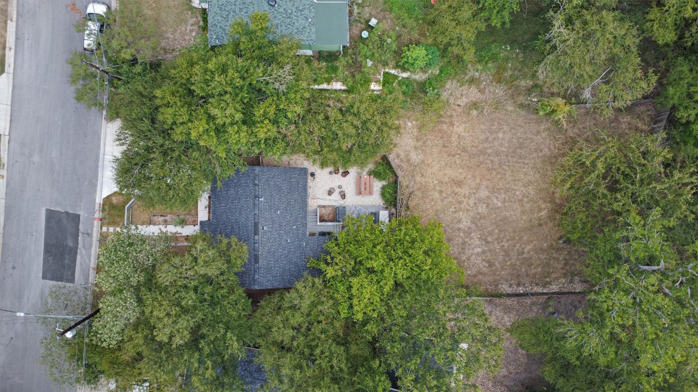 an aerial view of a house with a yard and large tree