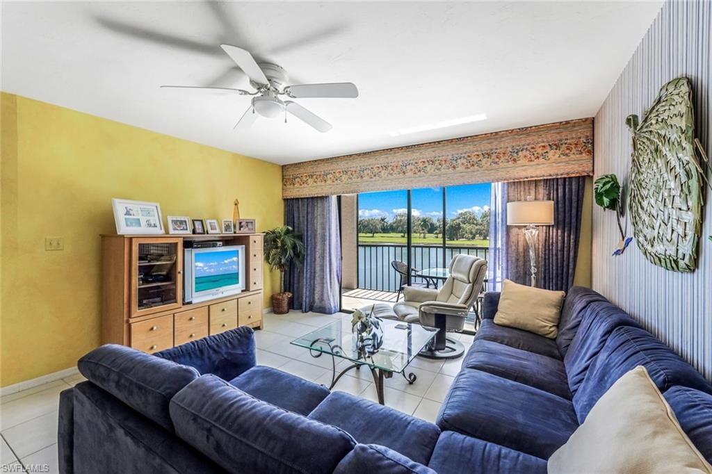 a living room with furniture ceiling fan and a large window