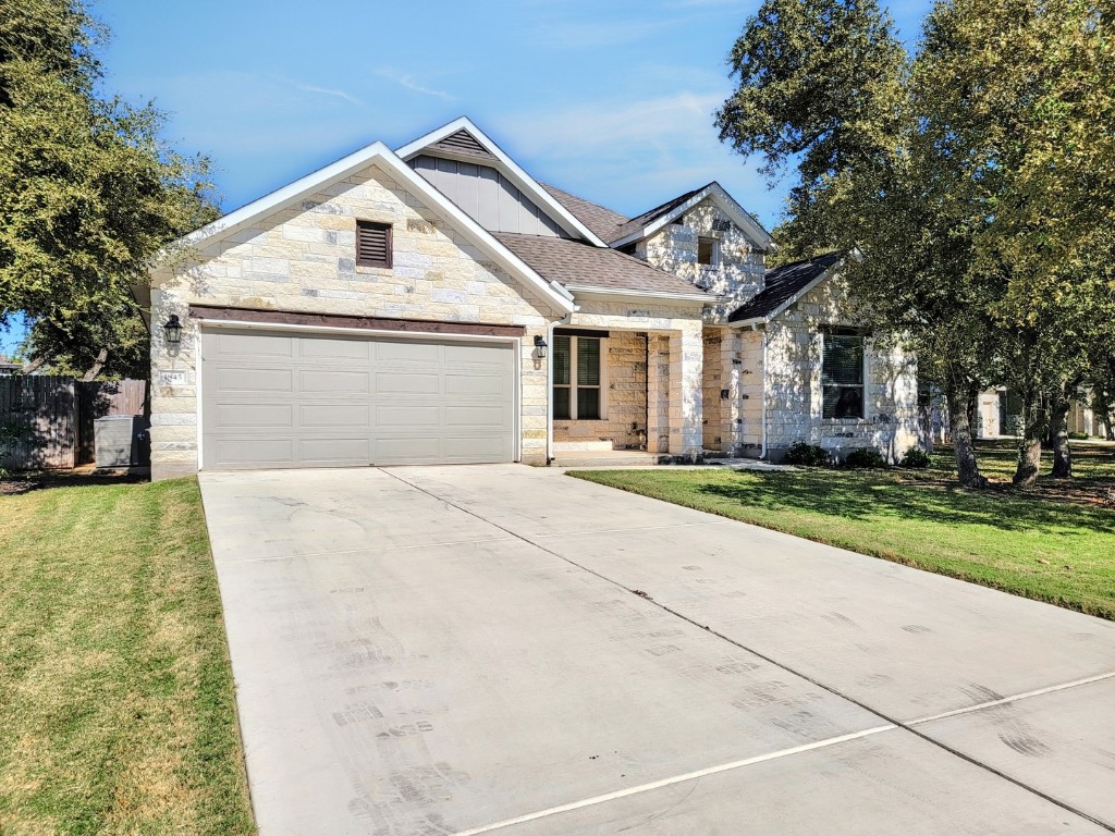 a front view of a house with a yard and trees