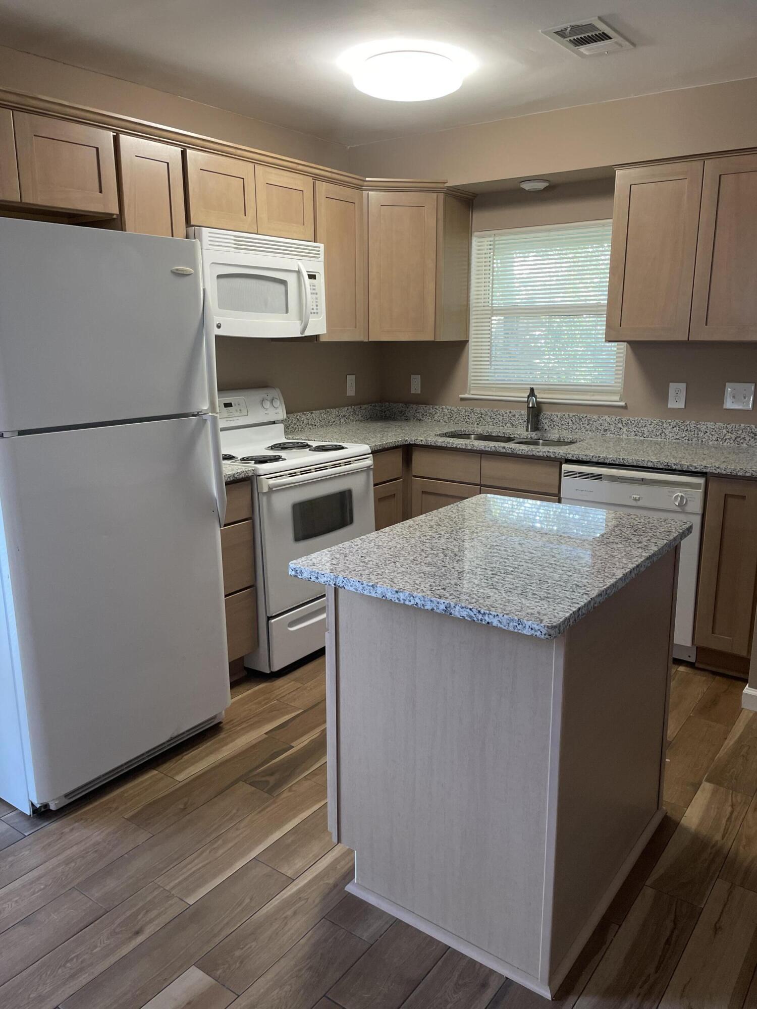 a kitchen with a refrigerator sink and cabinets