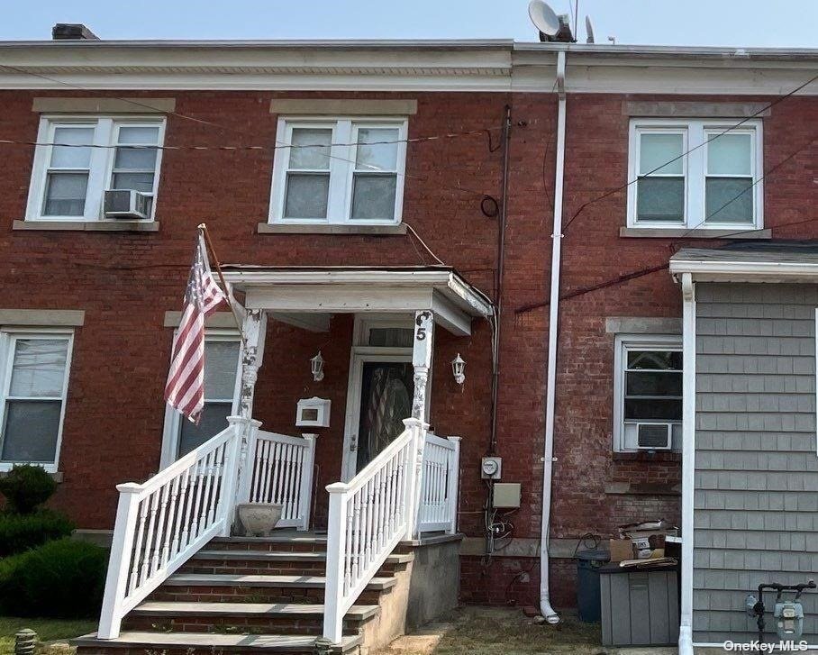 front view of a brick house with large windows