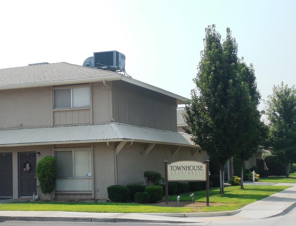 a view of a house with a yard and potted plants