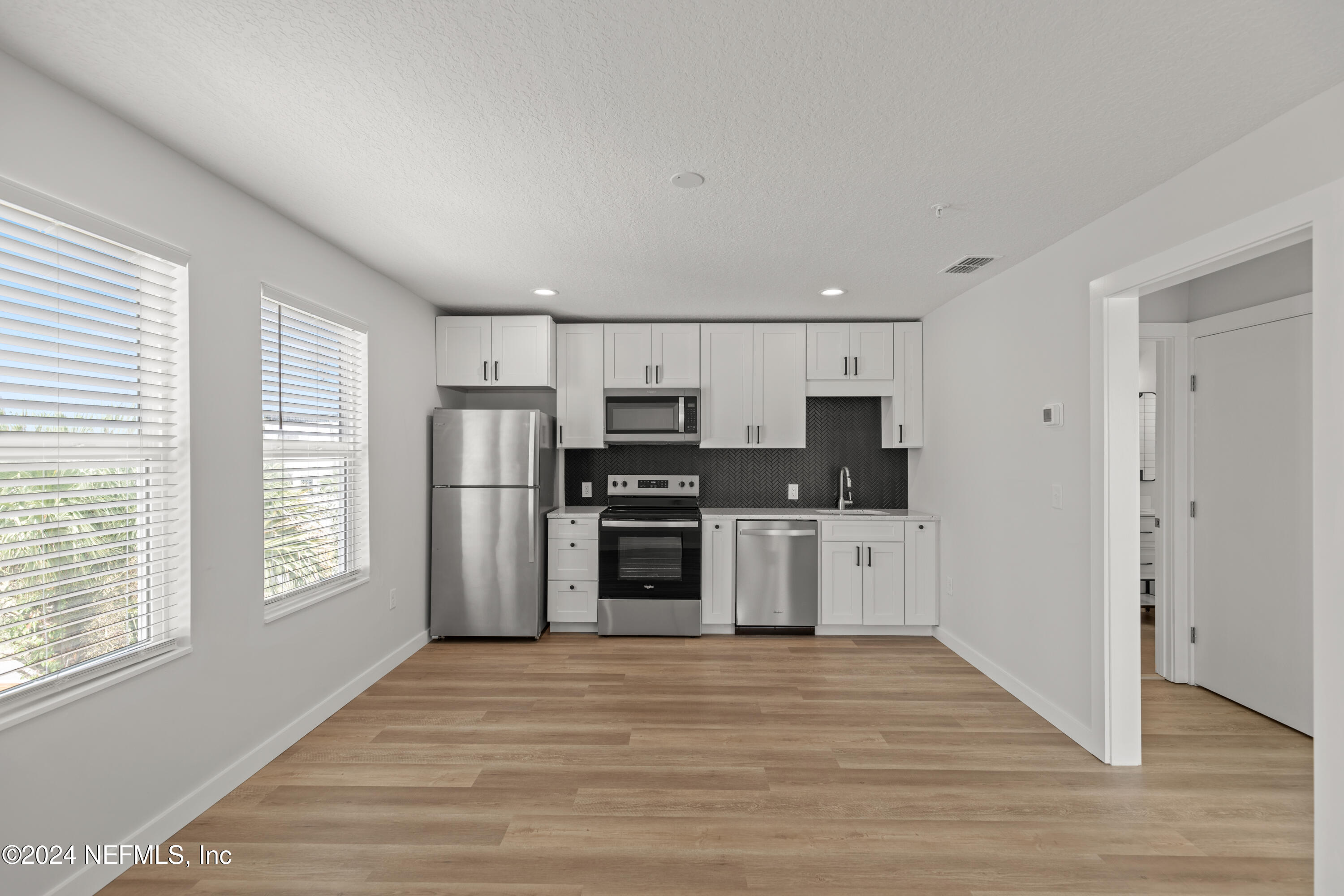 a kitchen with stainless steel appliances a refrigerator sink and cabinets