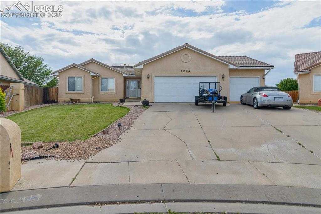 Ranch-style home with a front lawn and a garage