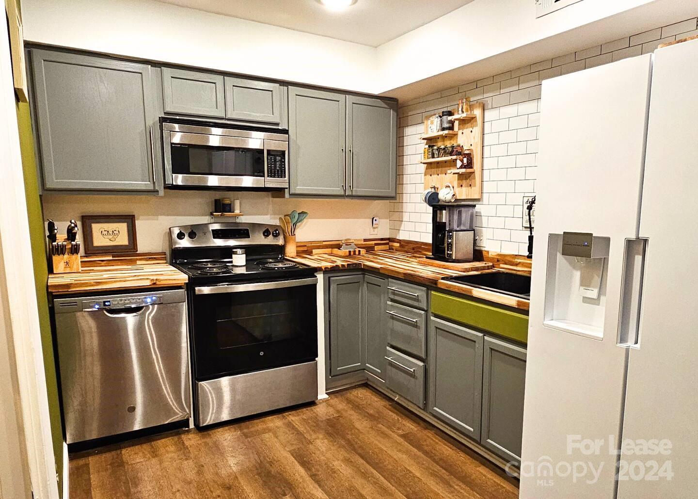 a kitchen with stainless steel appliances granite countertop a stove a sink and a microwave