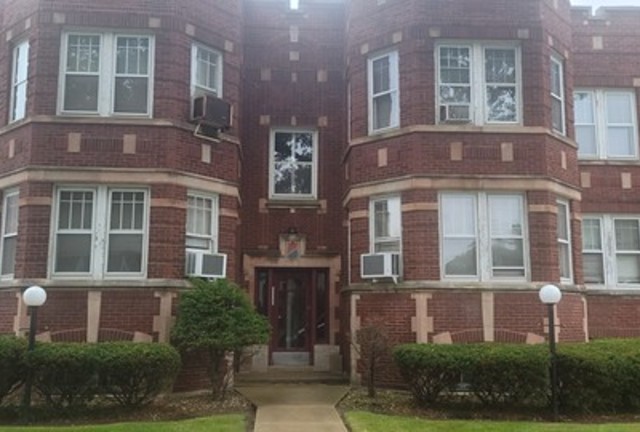 a front view of a residential apartment building with a yard