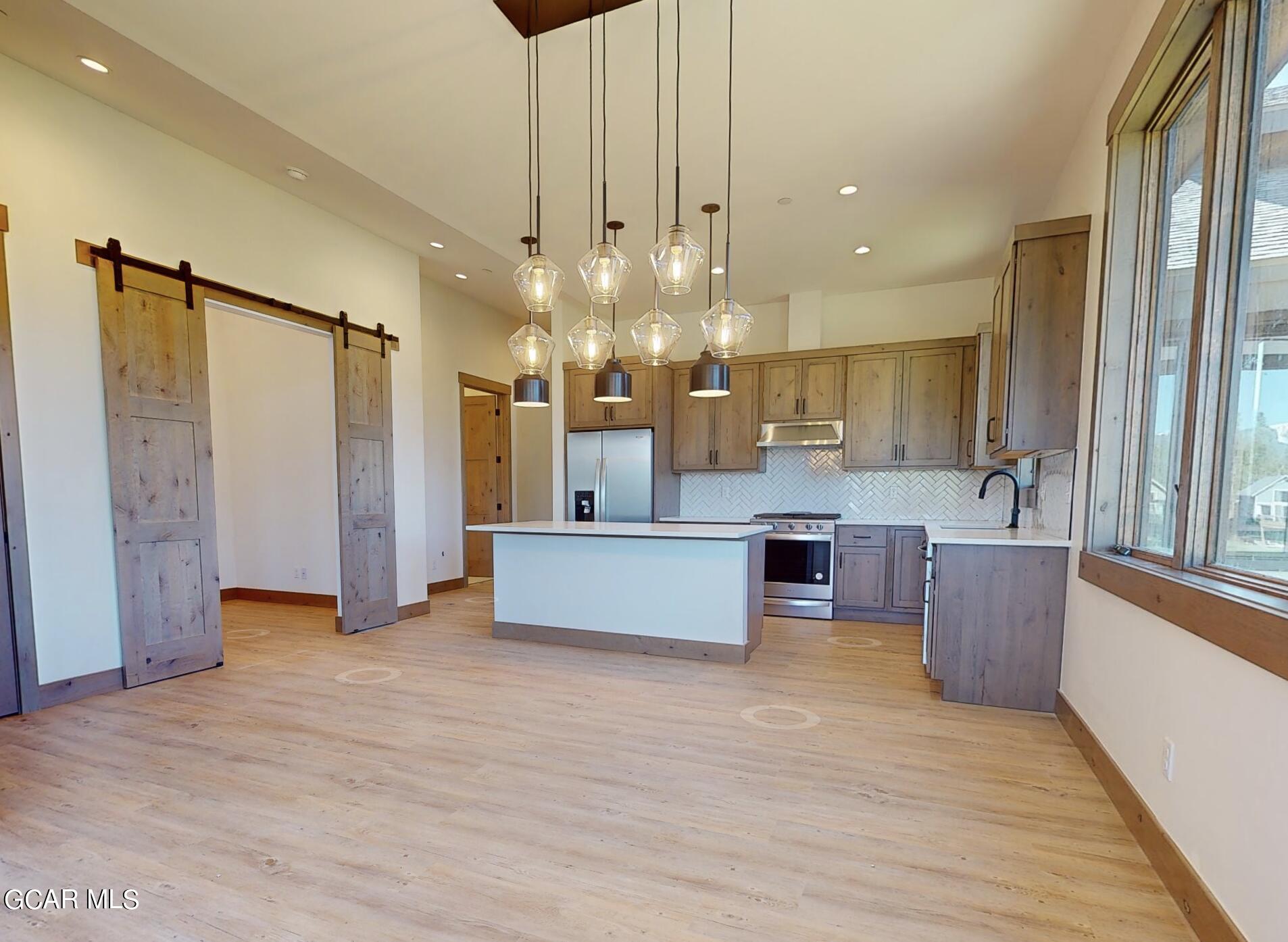 a large kitchen with a large window and stainless steel appliances