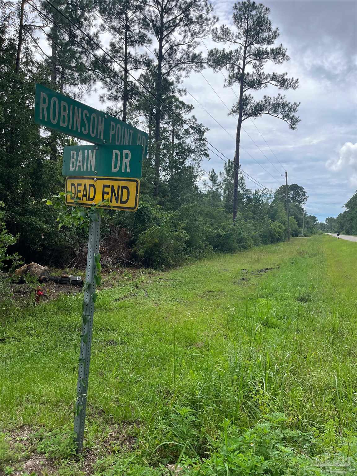 a street sign sitting on a lush green field