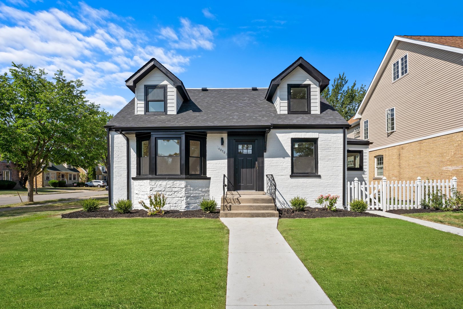 a front view of a house with a yard and fountain