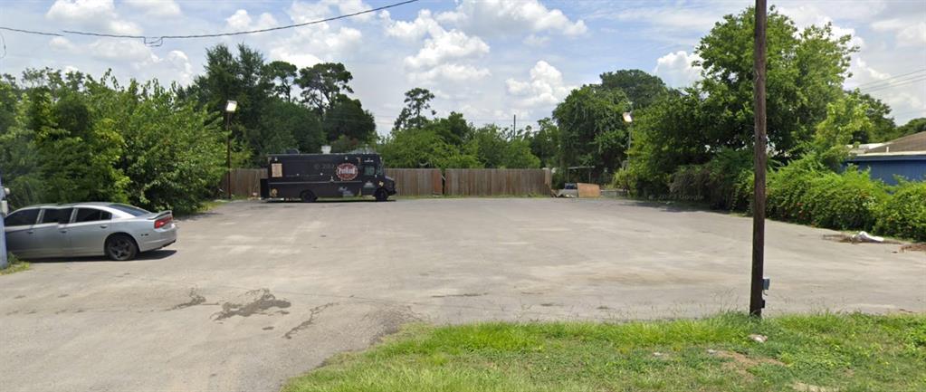 a view of backyard with a car parked in it