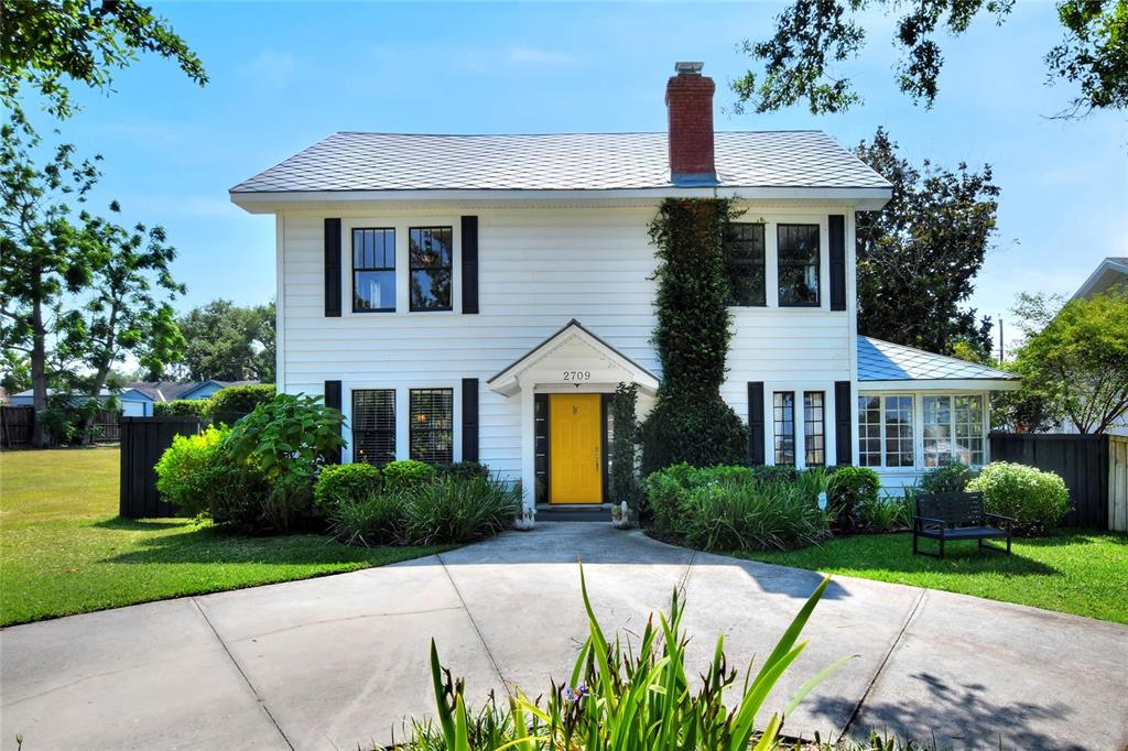 a front view of a house with a yard and potted plants