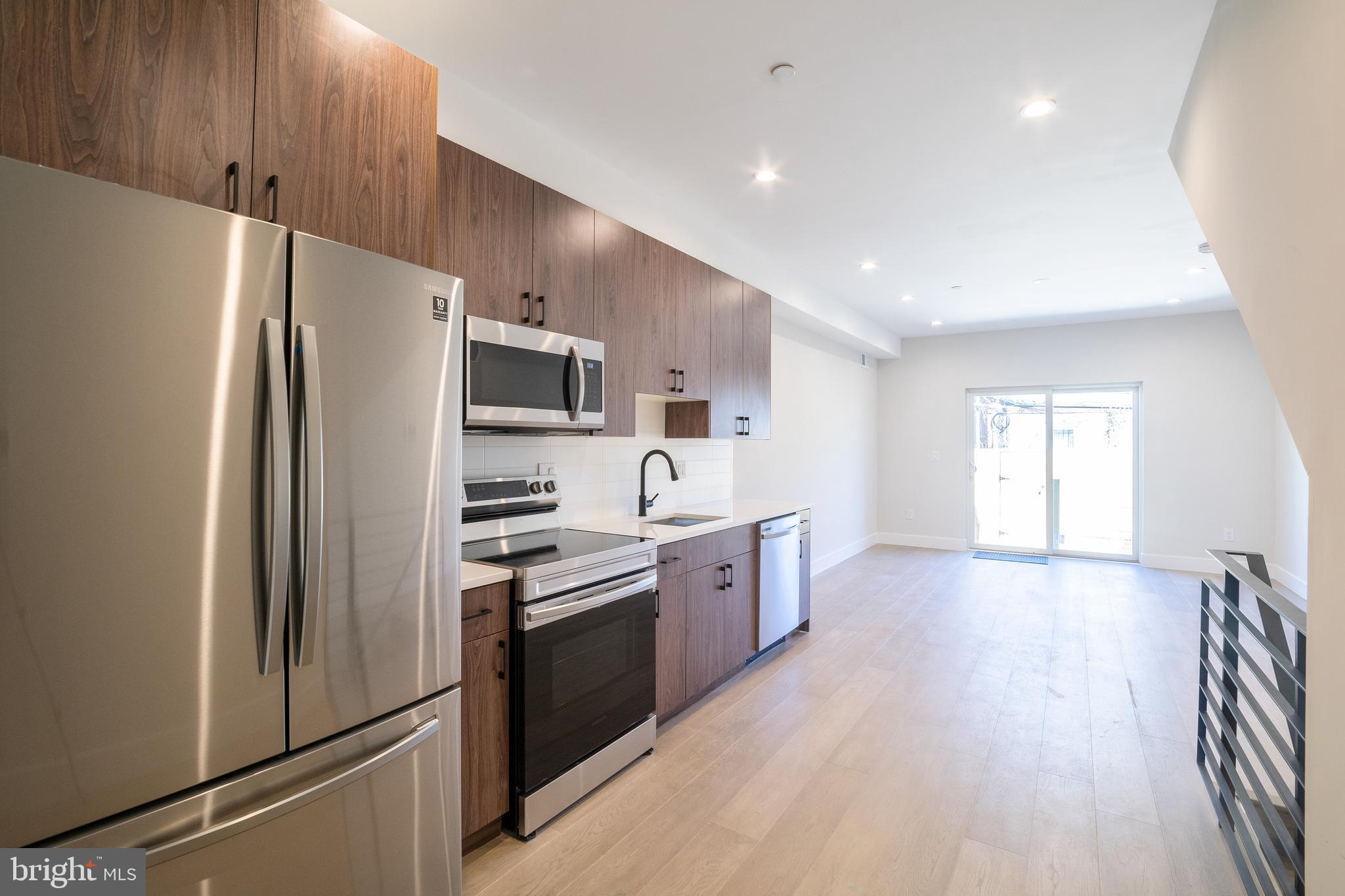 a kitchen with stainless steel appliances a refrigerator stove microwave and cabinets