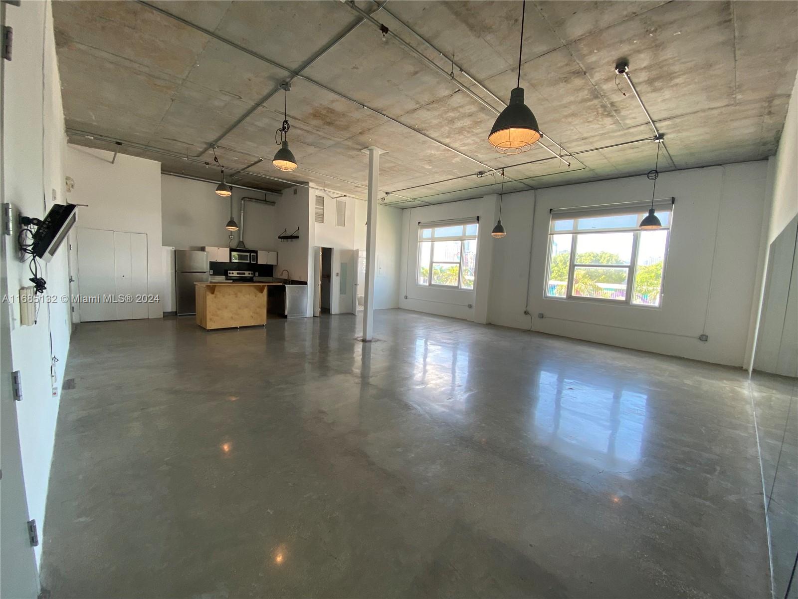 a view of a room with lots of wooden furniture and windows