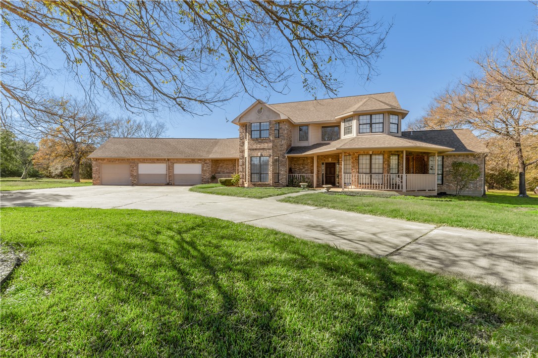 View of front of house with a porch, a garage, and