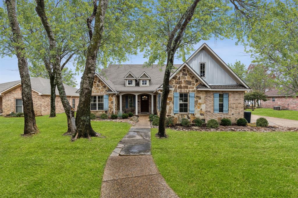 a front view of a house with a yard and tree