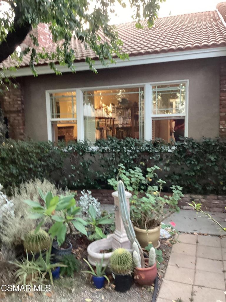 a view of a chair and table in backyard of house