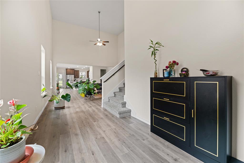 a hallway with wooden floor and stairs