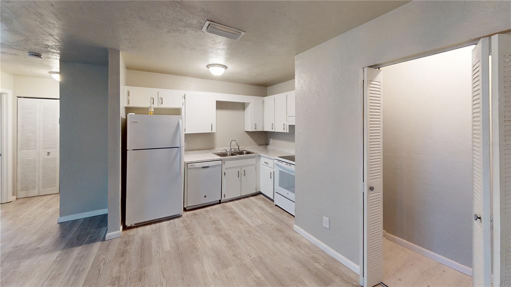 a kitchen with white cabinets and white appliances