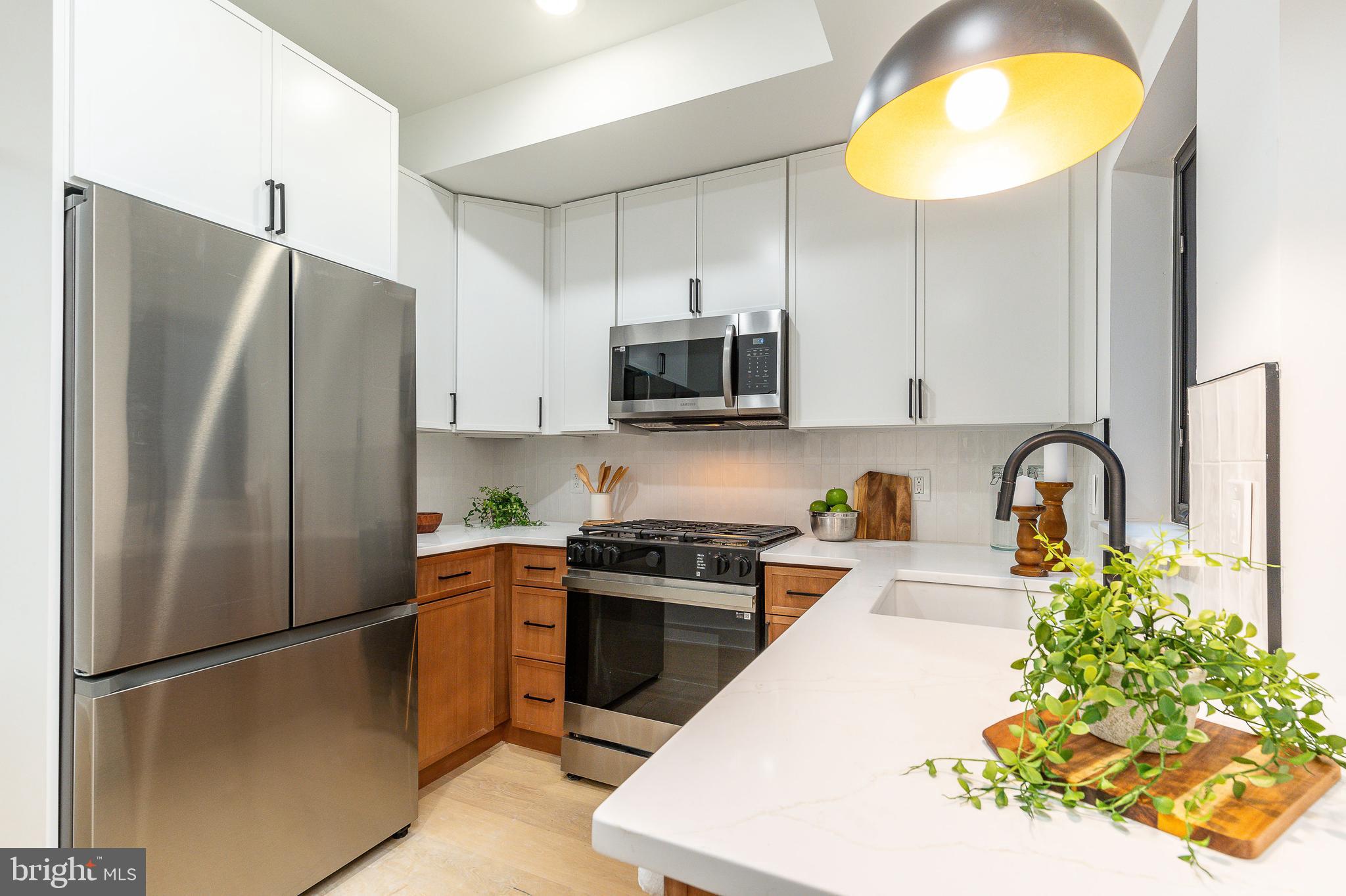 a kitchen with stainless steel appliances granite countertop a refrigerator and a stove top oven