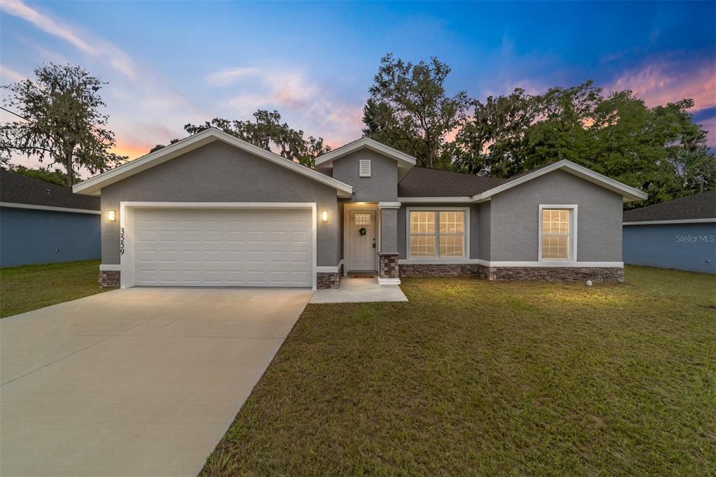 a view of a house with a yard and garage