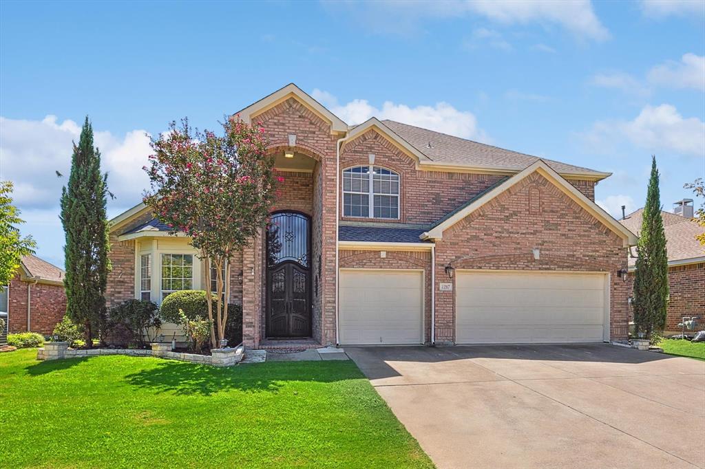 a front view of a house with a yard and garage