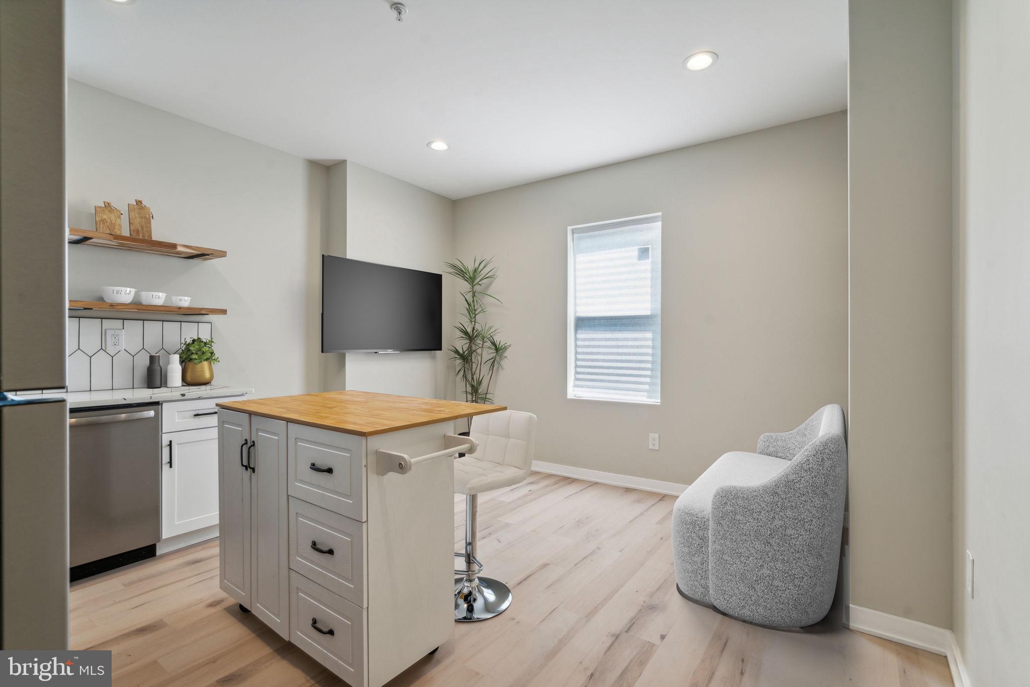 a living room with stainless steel appliances kitchen island a stove a refrigerator and a stove