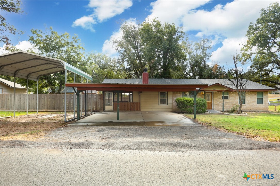 a front view of a house with a yard and trees